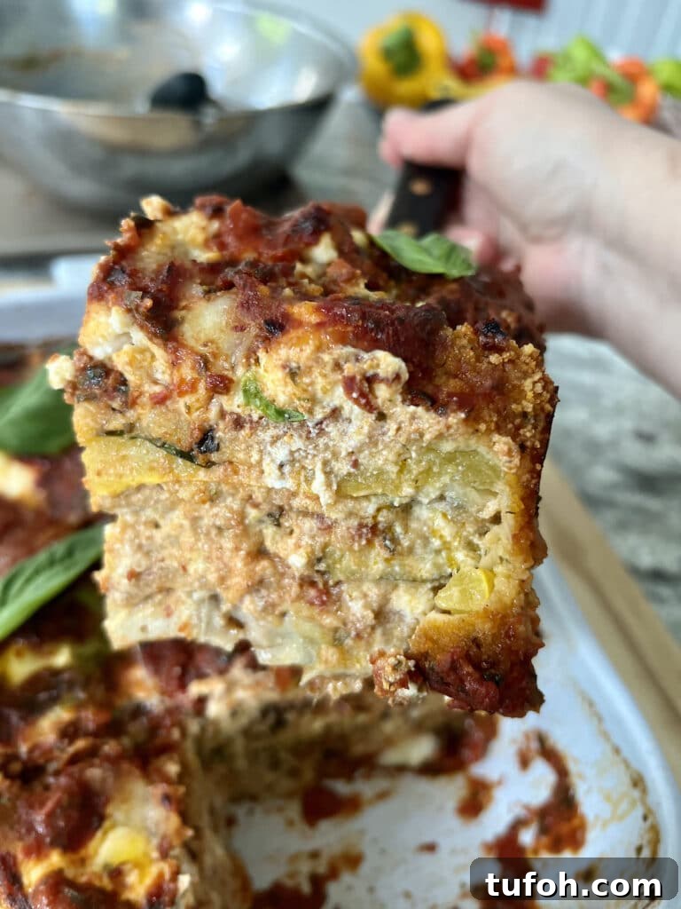 Zucchini Parmigiana with Ricotta: Layered Baked Zucchini Parmesan 4 Slice of parmigiana di zucchini held on spatula, showing the cut view.