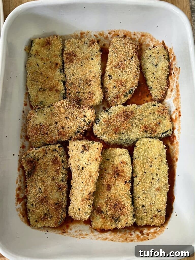 Zucchini Parmigiana with Ricotta: Layered Baked Zucchini Parmesan 7 Building the dish: baked, breaded zucchini arranged in single layer over sauce.