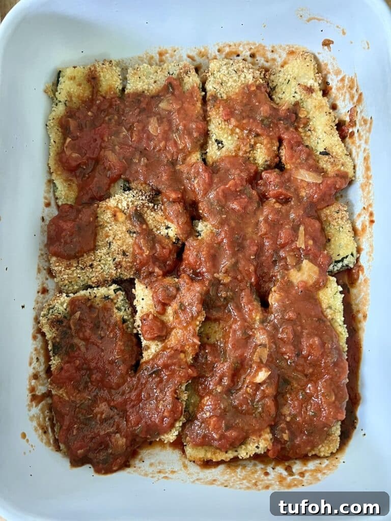 Zucchini Parmigiana with Ricotta: Layered Baked Zucchini Parmesan 8 Building the parm: Tomato sauce spread over the baked, breaded zucchini.