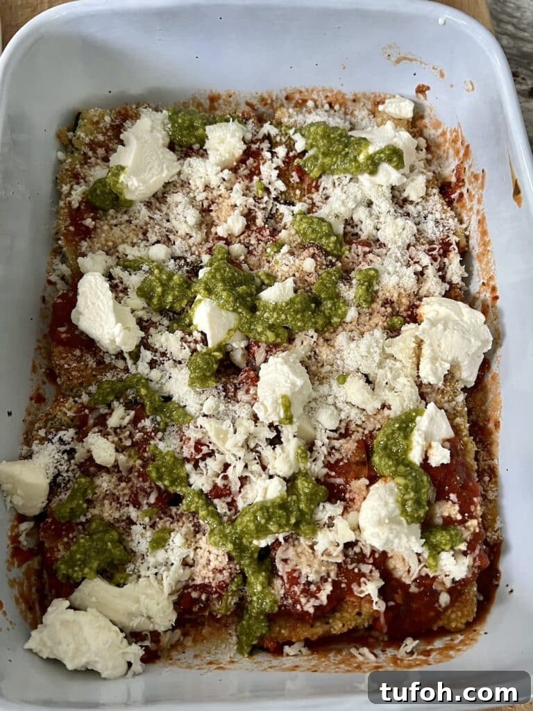 Zucchini Parmigiana with Ricotta: Layered Baked Zucchini Parmesan 10 Building the zucchini parmigiana: Pesto drizzled over the cheese layer.