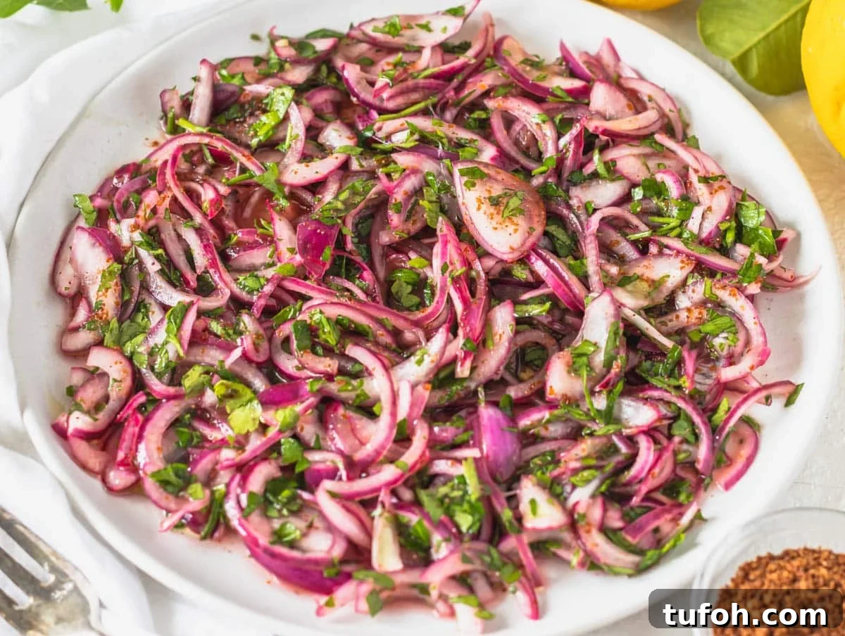 Sumac onions on a white plate with fresh parsley
