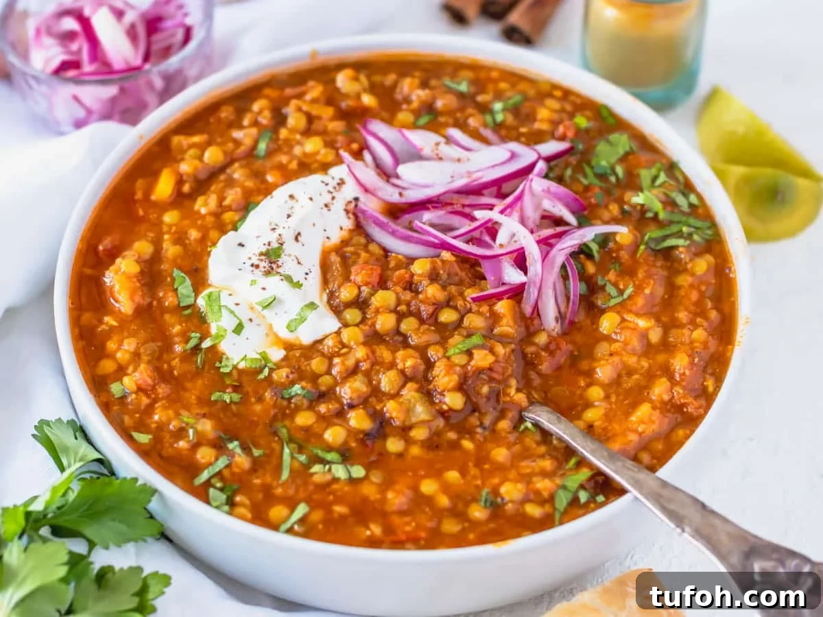 Moroccan lentil soup with a silver spoon and pickled red onions