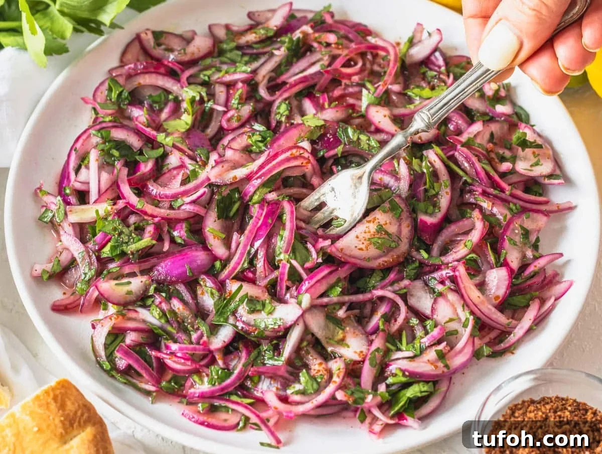 Sumac onions with hand holding a silver fork