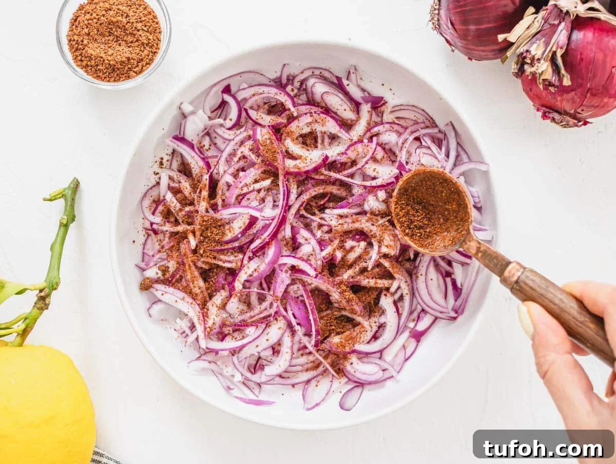 sliced red onions in a white bowl with sumac