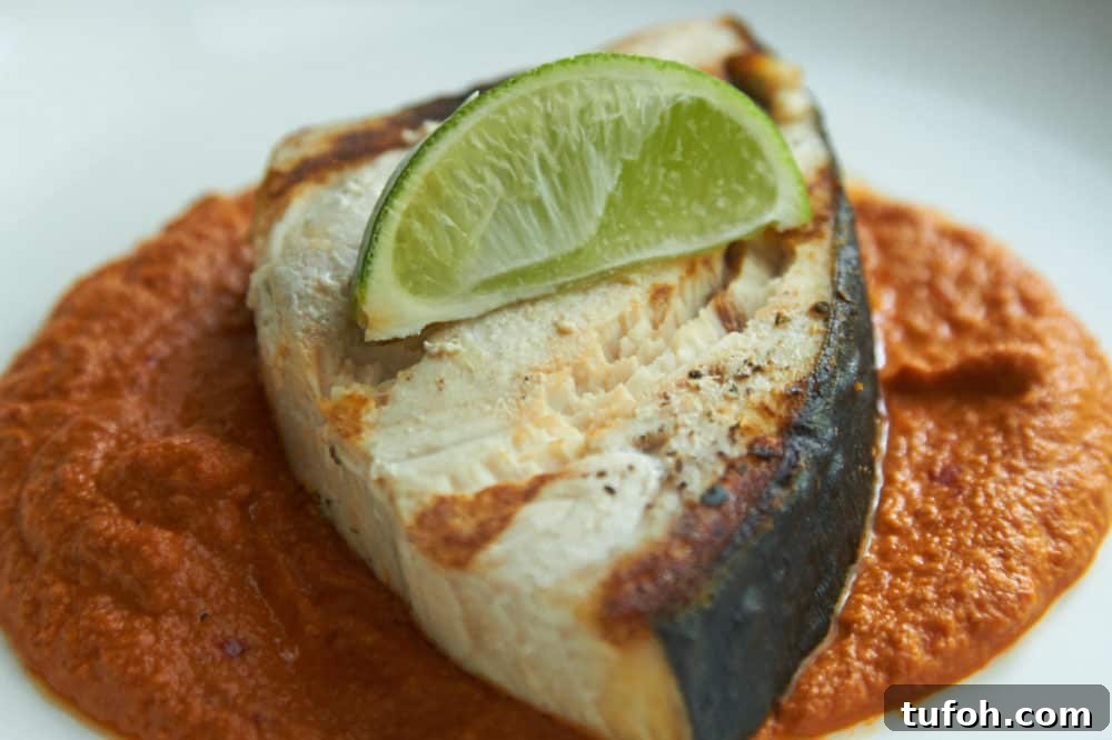 Orange-Almond Mole Sauce: Quick Recipe for Vibrant Flavor 2 Grilled halibut with Almond orange mole, garnished with a lime wedge.