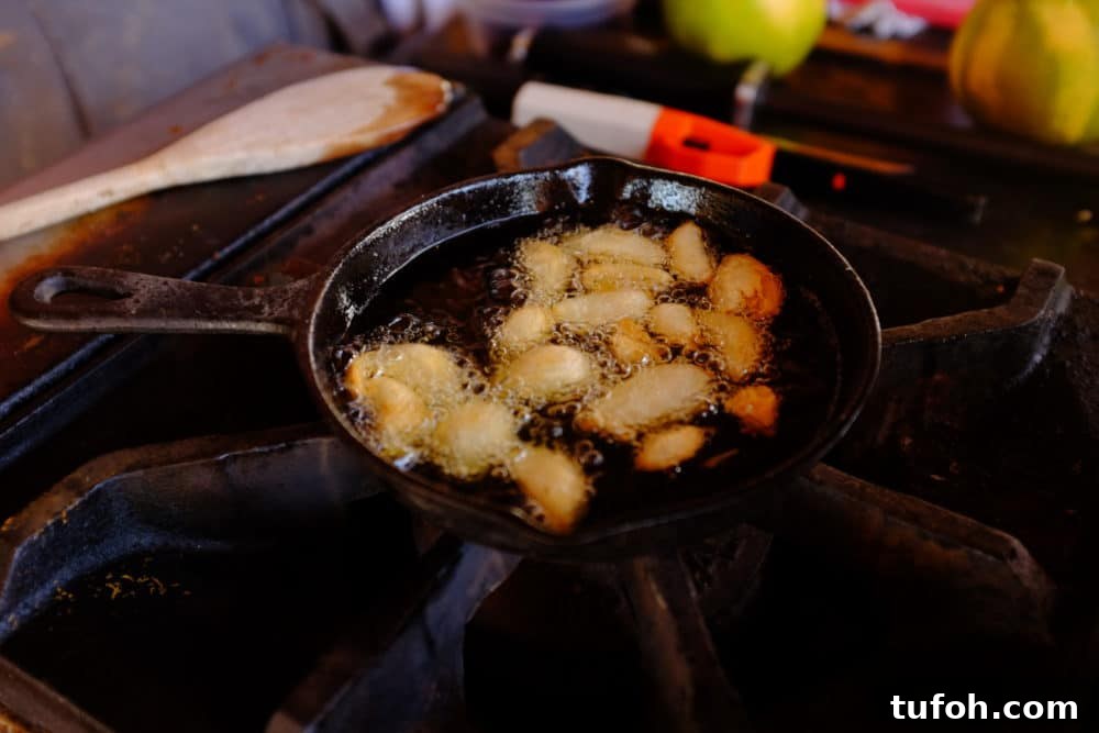 Orange-Almond Mole Sauce: Quick Recipe for Vibrant Flavor 6 Almonds frying in a cast iron skillet on a large gas stovetop.