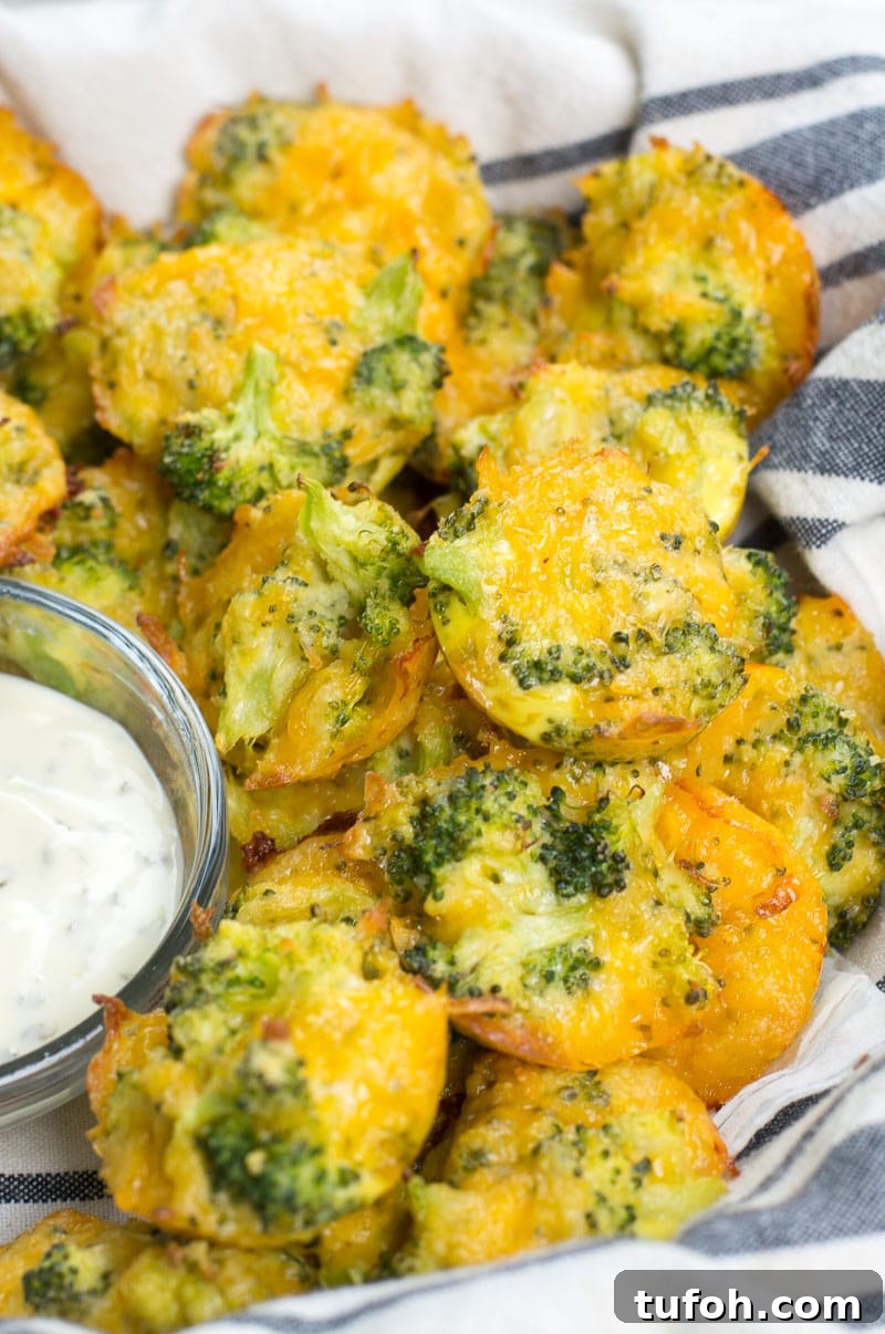 a pile of cheesy broccoli bites in a striped towel next to a small dish of ranch