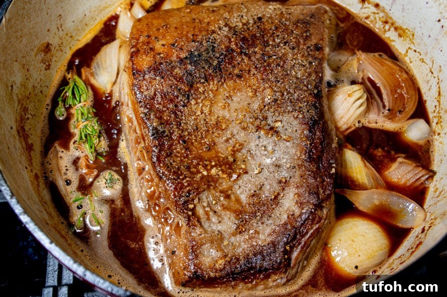 a pot of brisket onions herbs and wine before it's braised