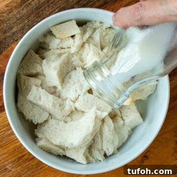 Milk being pour from a bottle onto white bread.
