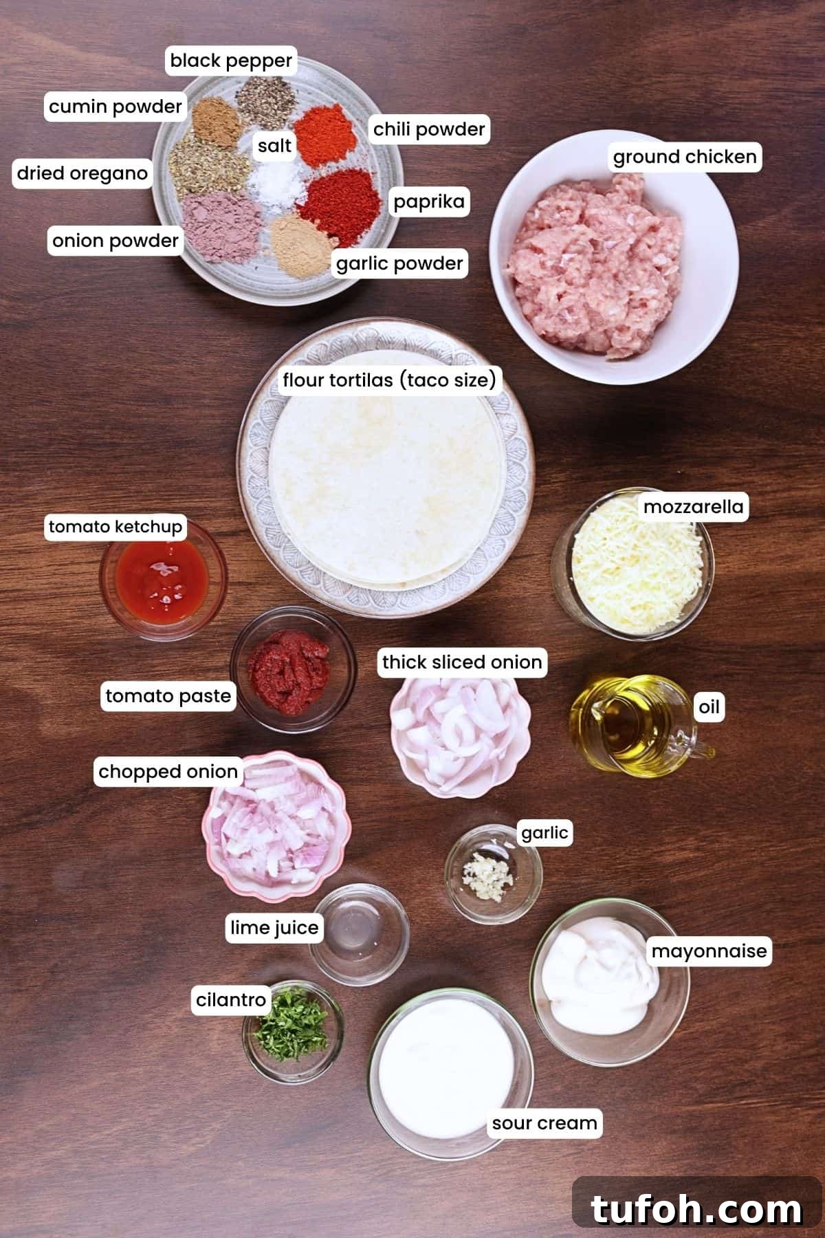All ingredients for ground chicken tacos including chicken, tortillas, mozzarella, onion, and seasoning spices.