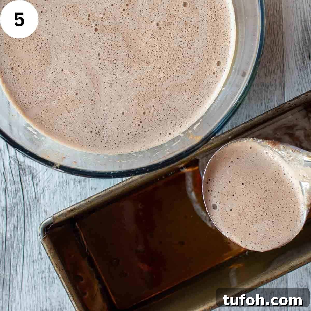 Light brown liquid being ladled into a loaf pan.