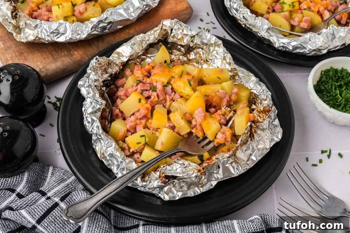 Diced potatoes and ham on a piece of foil on a black plate