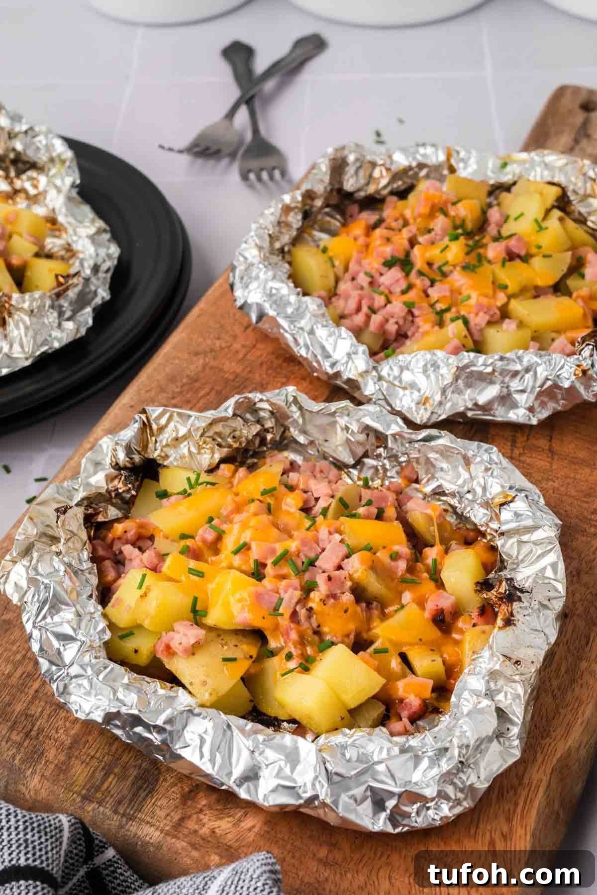 Ham and potatoes foil packet on a cutting board