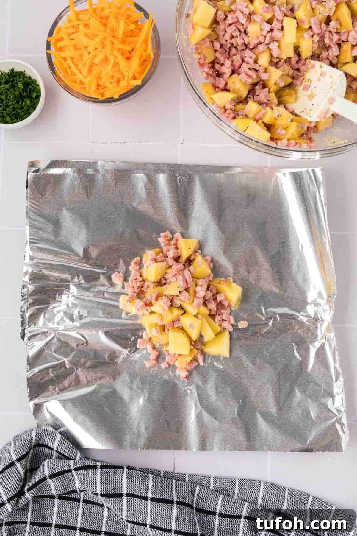 Dividing diced ham and potatoes on a piece of foil
