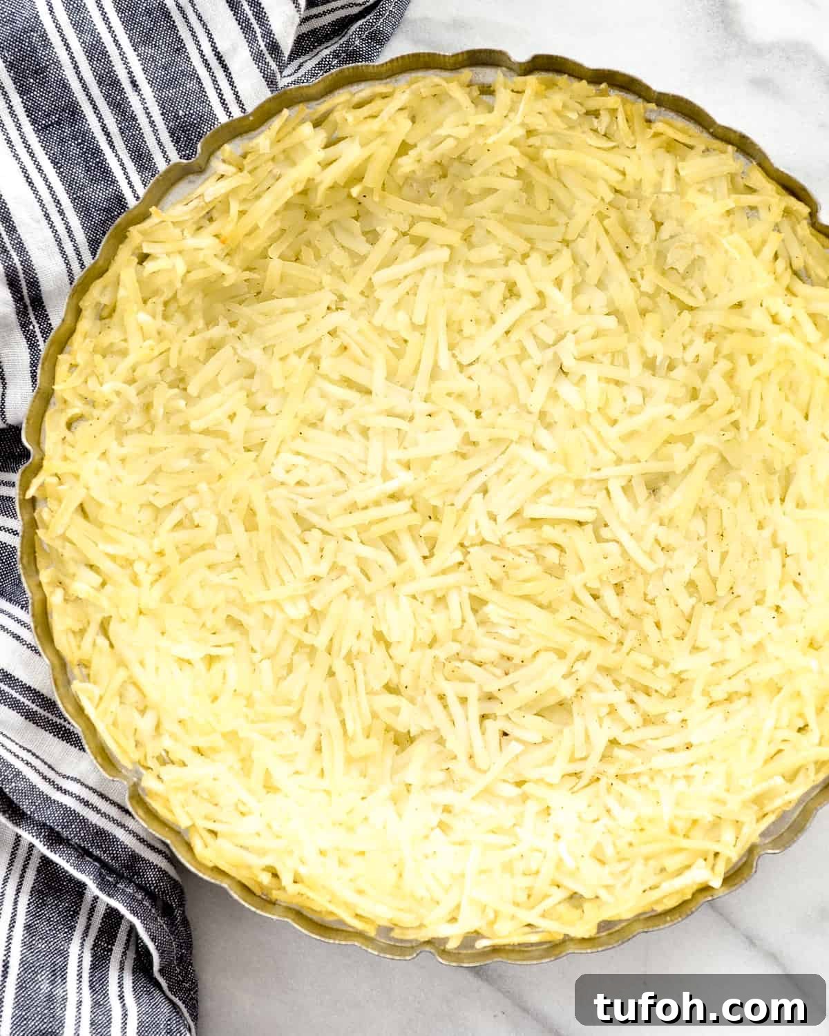 Overhead view of the hash brown crust being made in Gluten-Free Hash Brown Quiche 