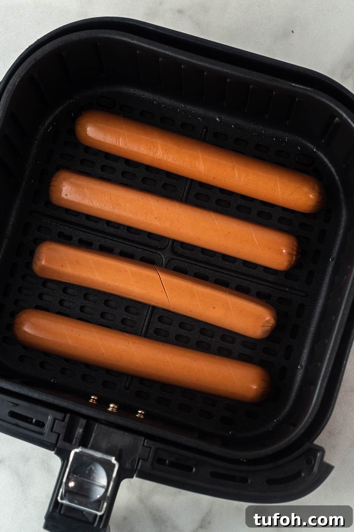 uncooked hot dogs in the air fryer.