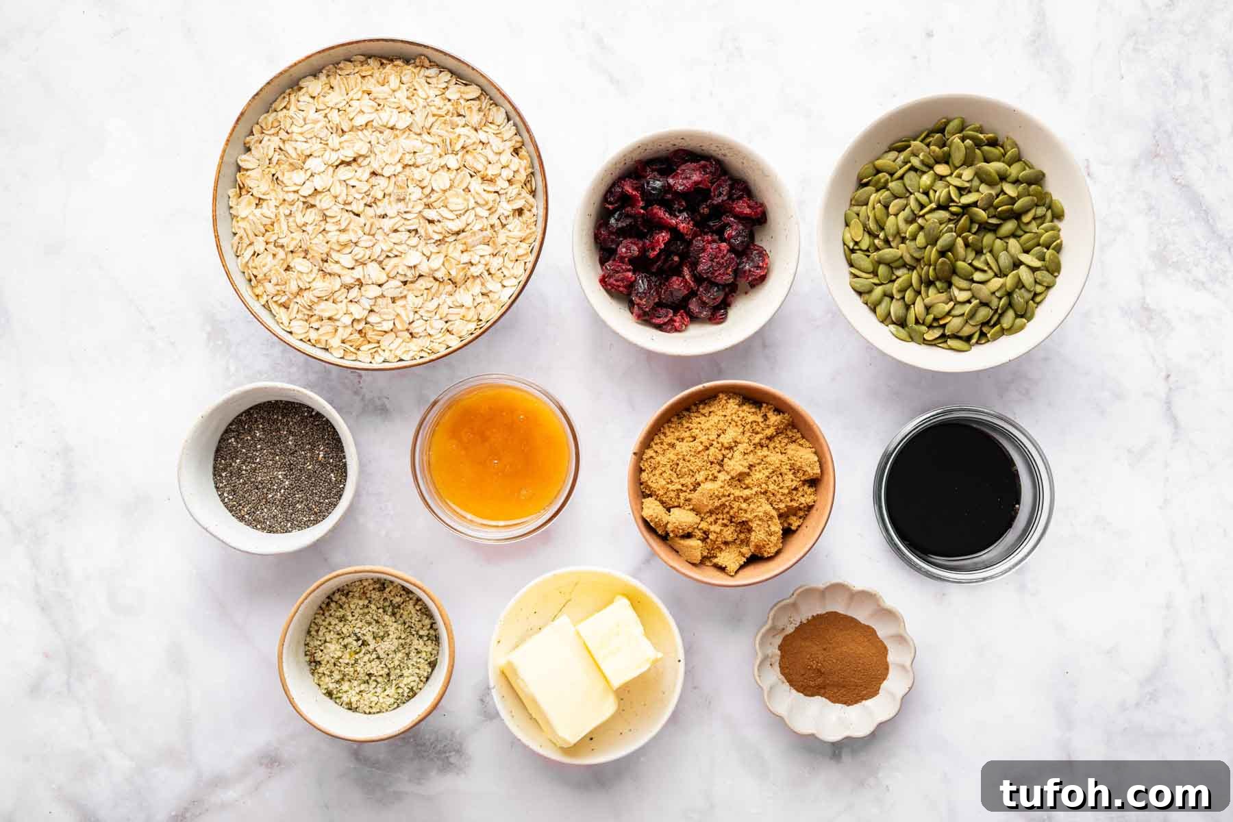 Bowl of oats, pumpkin seeds, brown sugar, melted butter, chia seeds and cranberries.