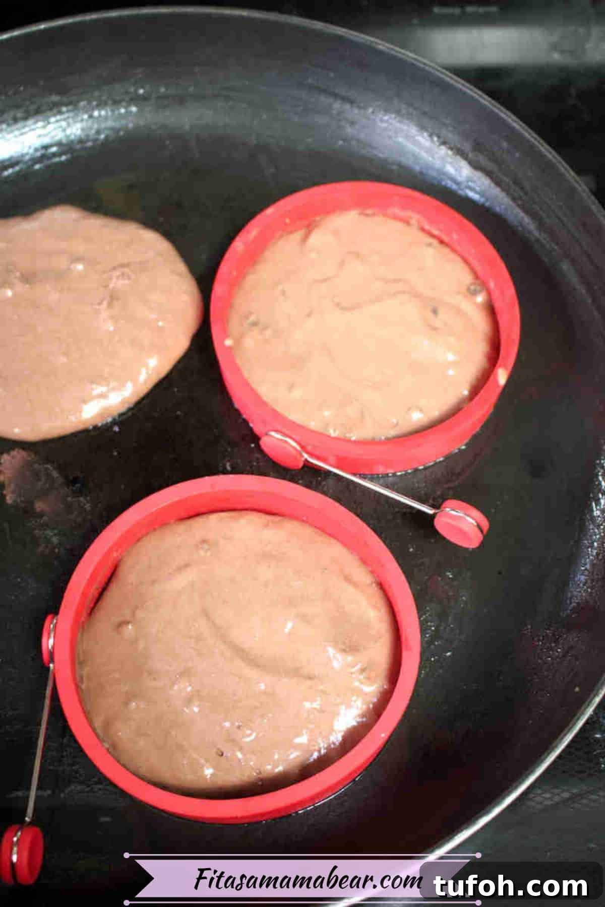 Protein pancakes in a black frying pan with silicone molds.