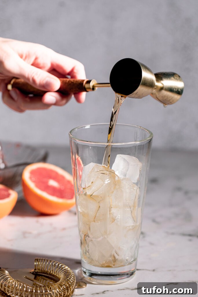 Pouring bourbon into a cocktail shaker.