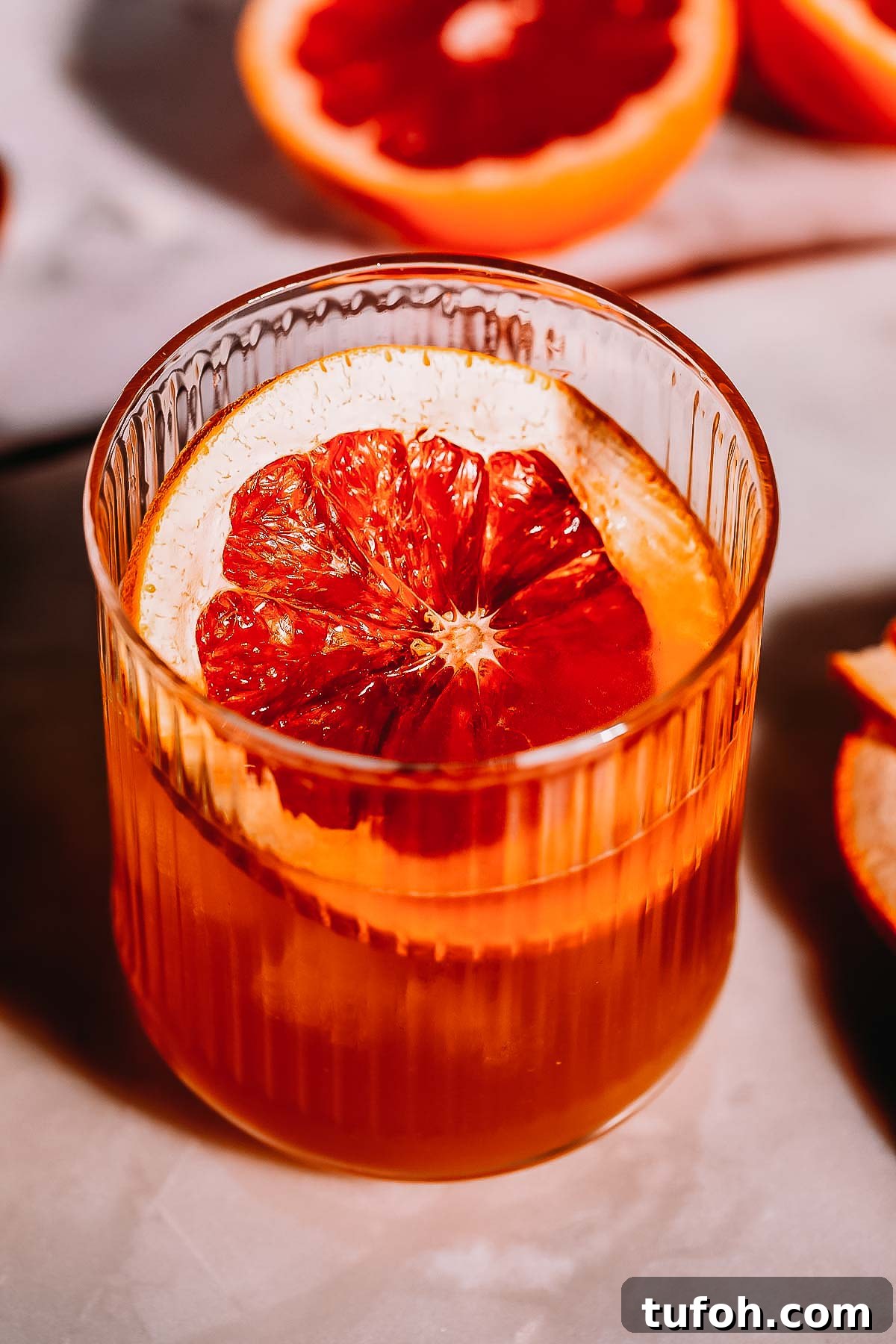Overhead shot of a grapefruit garnish in a cocktail glass.